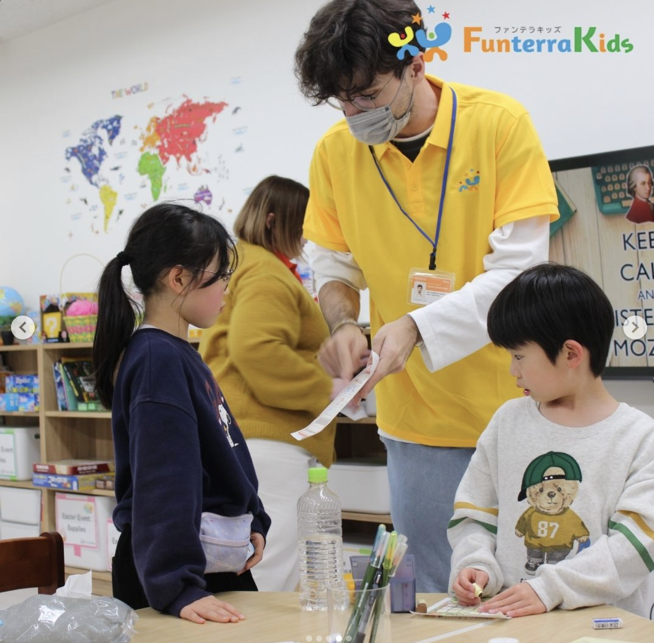 おやつを囲み、先生のクイズに元気よく手を挙げる子どもたち